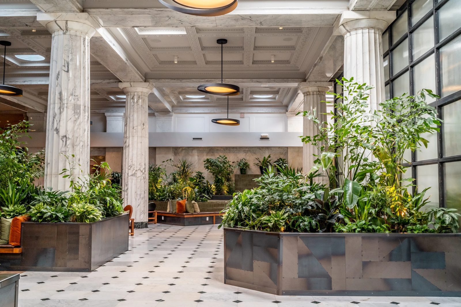 Hotel Emery lobby event space in Minneapolis with marble columns, lounge seating, and lush planters